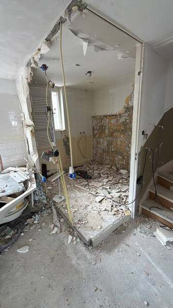 Badkamer tijdens sloop, meerdere vloerlagen zichtbaar
